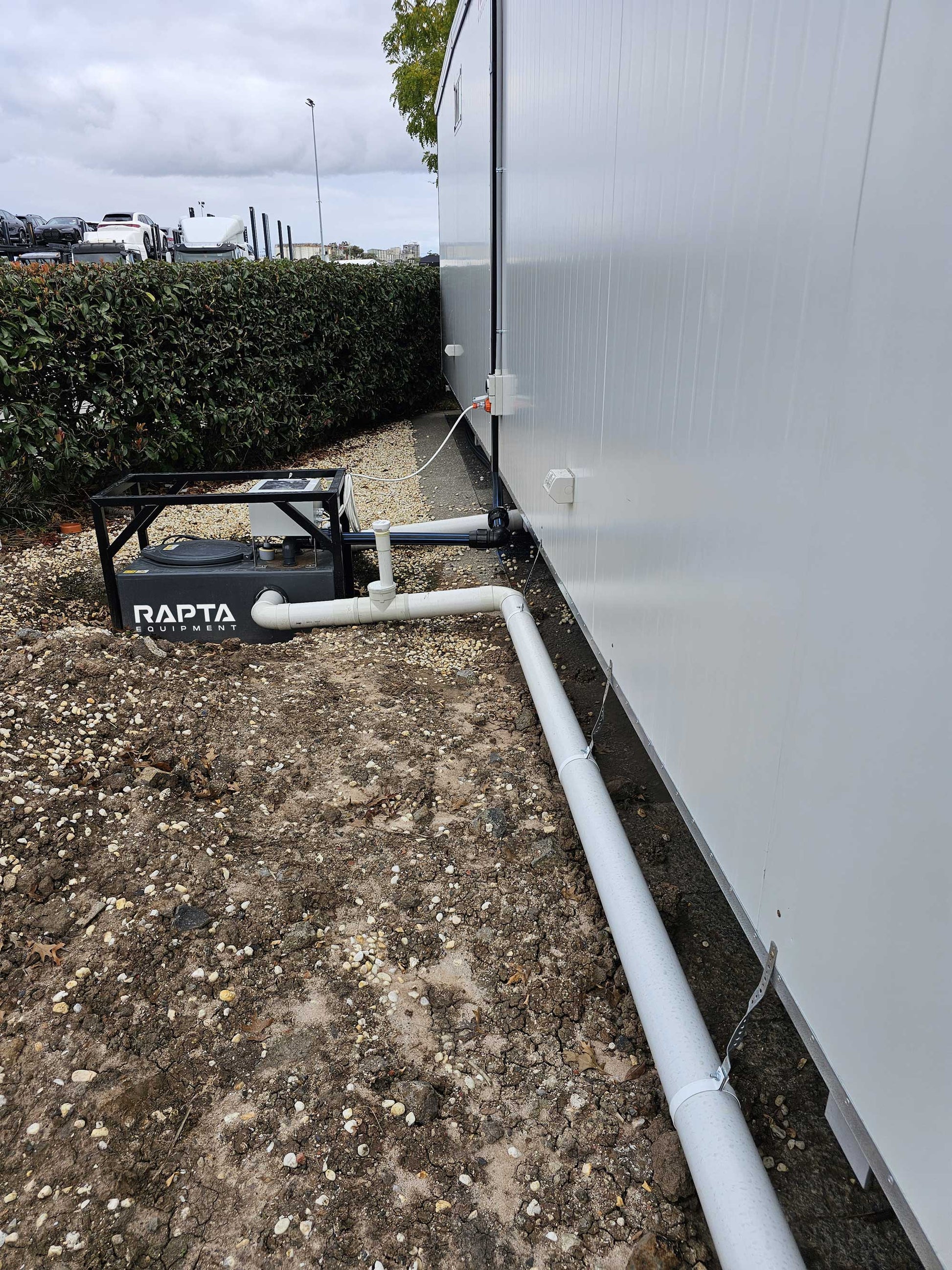 RAPTA CabinPump Ultra connected to a modular building with wastewater inlet and discharge pipework