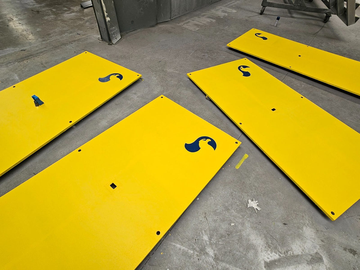 Multiple yellow anti-slip coated RAPTA heavy-duty steel road plates with fixing holes and RAPTA branding