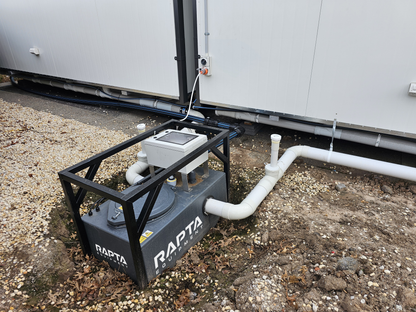 RAPTA CabinPump Ultra wastewater system installed and connected beside a modular site building