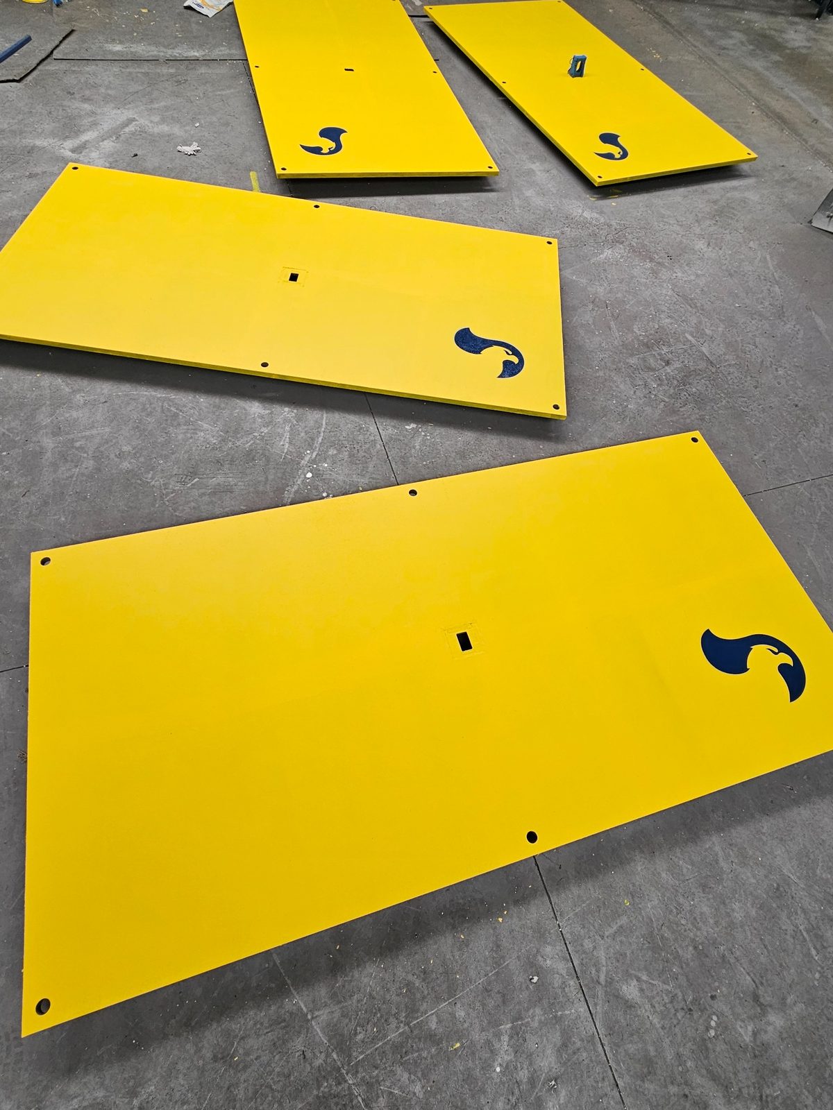 Multiple yellow anti-slip coated RAPTA heavy-duty steel road plates with fixing holes and RAPTA branding