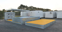 RaptaCover™ modules stacked for storage beside an assembled RaptaCover™ system, with a RAPTA 10,000L Water Supply Skid in the background