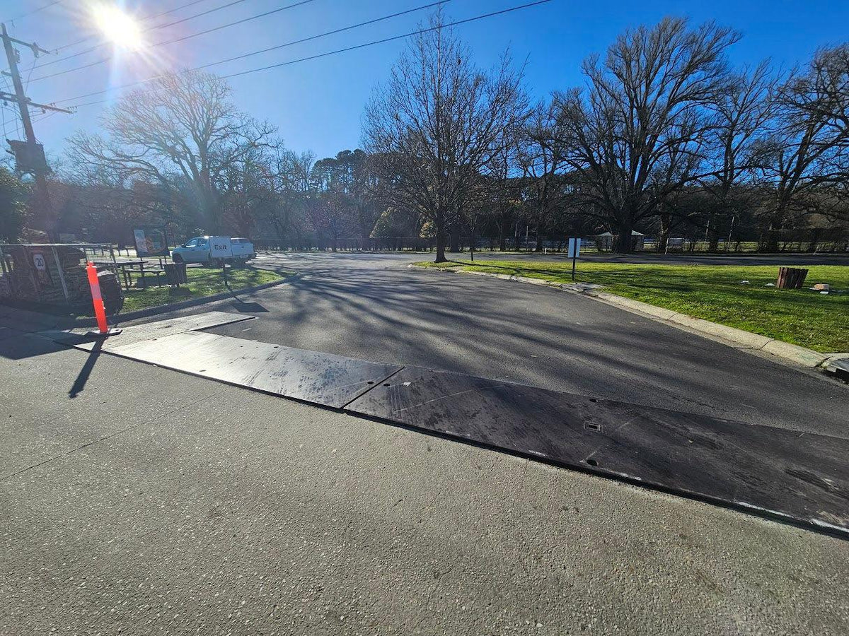 Uncoated RAPTA steel road plates installed across a site driveway.