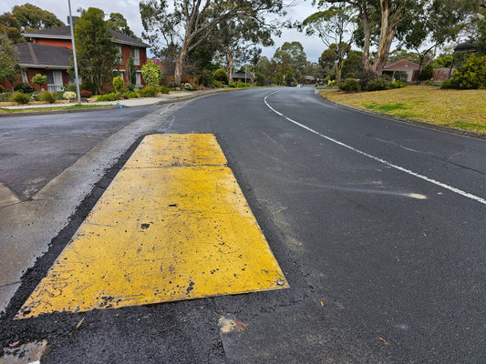 Yellow anti-slip RAPTA steel road plate installed on a road.