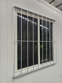 RAPTA 1250 x 1260mm galvanised window security grill installed on a portable building, angled view